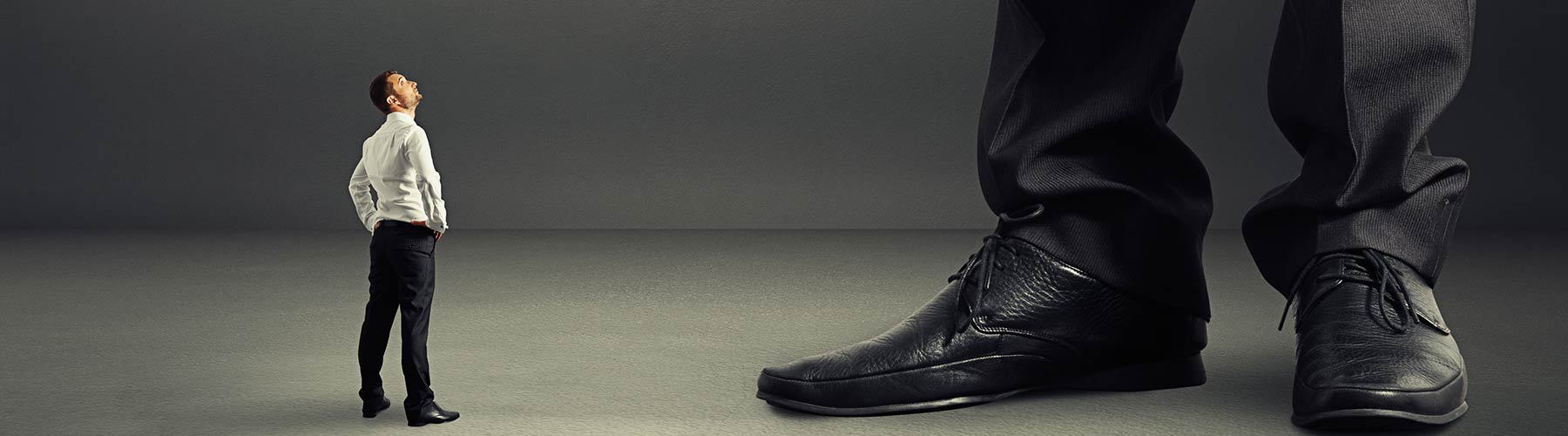 businessman looking up at a much larger business person